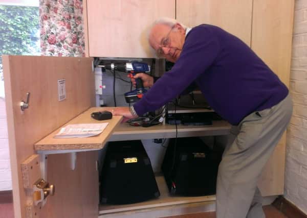 Paul Webster, chairman of the Ferring Village Hall committee, repairs cupboard damaged in theft