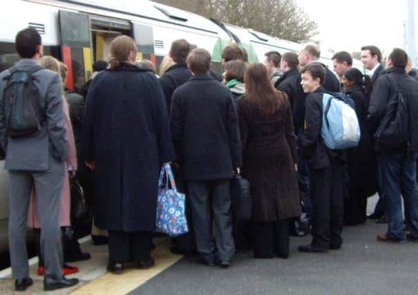 Commuters queueing to get onto a train