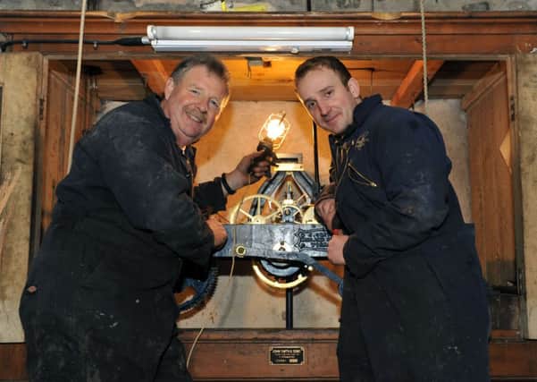 S08032H14 Engineers Dave Clarke, left, and Luke Ridge at work on the clock mechanism