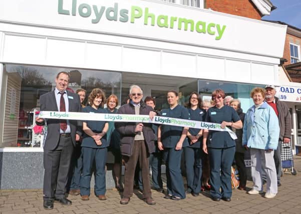 LLOYDS PHARMACY BILLINGSHURST - PICTURED  CUSTOMER DON (DONALD) BAIN  CUTTING THE TAPE WITH TEAM MEMBERS