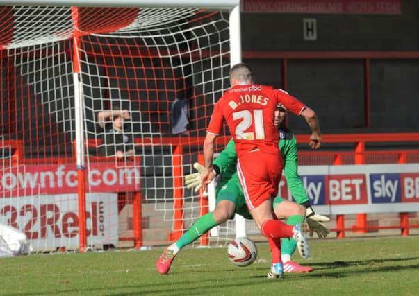 Crawley's Mike Jones dribbles past Sam Walker  to score against Colchester (Pic by Jon Rigby)