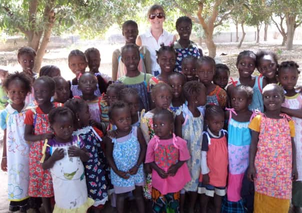 Esther Clark started a project to 'dress a girl around the world' and recently took 170 dresses to The Gambia SUS-140317-104013001