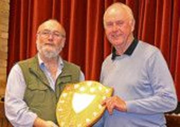 Steyning Camera Club chairman Michael Williams, right, receives the trophy from Marcus Scott-Taggart
