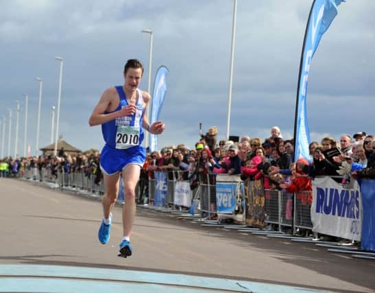 Ben Fish crosses the line to finish second in the 30th Hastings Half Marathon. Picture by Steve Hunnisett