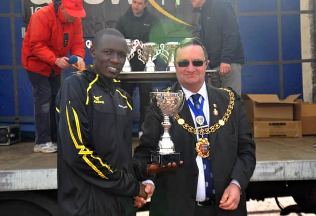 Hastings Half Marathon winner Boniface Kongin receives his trophy. Picture by Steve Hunnisett