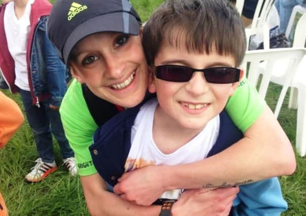 Caroline Toms, pictured, hugs her nephew Cameron, nine, who has Tourette's Syndrome. She will be running 100k for Tourettes Action