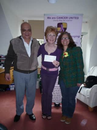 Jan Sheward, of Cancer United, is given a cheque by members from the Madeira Dancing and Singing Group.