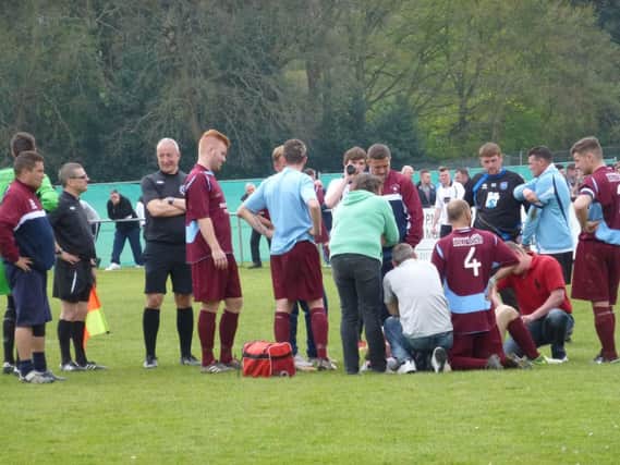 Concern is shown for Adam Smith after the Little Common attacking player suffered a suspected broken leg. Picture by Simon Newstead