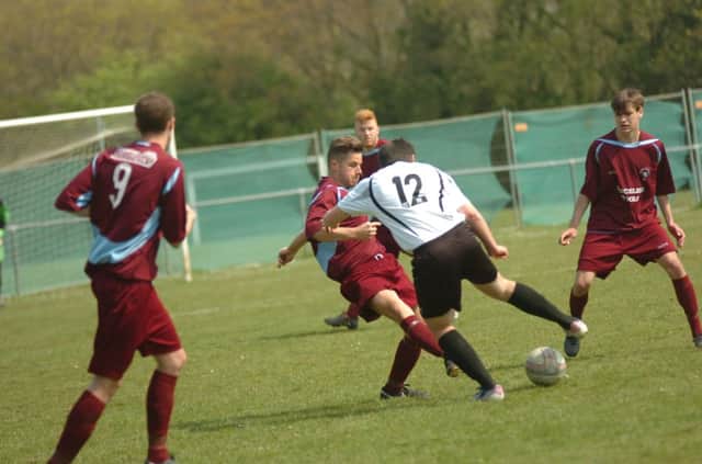 Little Common full-back Anthony Cooper and Bexhill United substitute Niall Macdonald tussle for possession. Picture by Simon Newstead