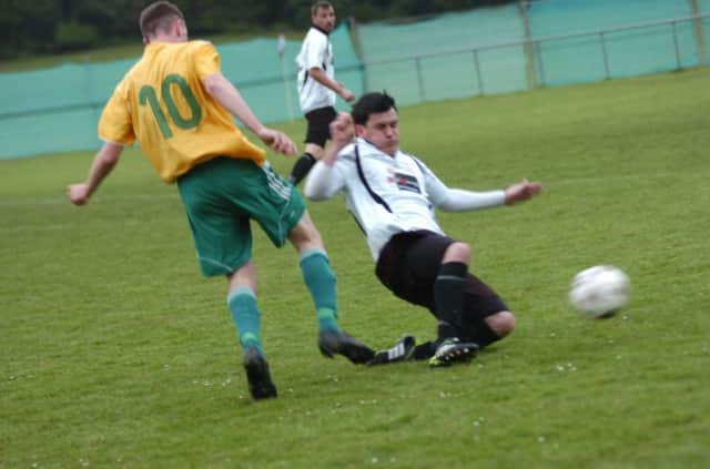 Bexhill United full-back Craig Ottley slides in to a tackle on Westfield forward Mike Booth