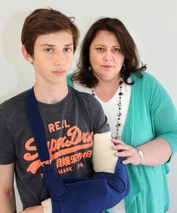 WH 290414 Tom Jefferis, 14, severely broke his arm and had to wait eight days before an operation. Pictured with his mum Carolyn. Photo by Derek Martin SUS-140430-094757001