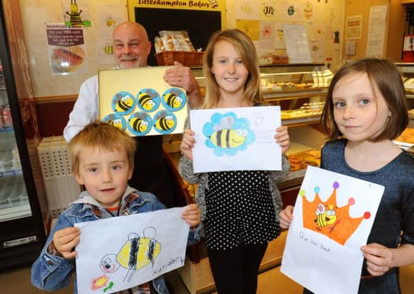 LG 200414 Painting or drawing competition at Littlehampton bakery, in Surrey Street, and then winning drawing being made into biscuits. Barkery owner John Durrant with winner Lana Collter 11,  and runners-up Xander Thornett 4 left and Emily Hunt 9. Photo by Derek Martin SUS-140420-235327001