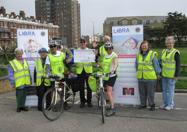 Members of Littlehampton and District Lions Club greeting two charity cyclists in the town