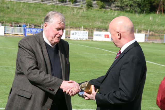 Outgoing Hastings United secretary Tony Cosens (left) receives a memento for his many years of service to the club from chairman Dave Walters (right). Picture by Terry S. Blackman