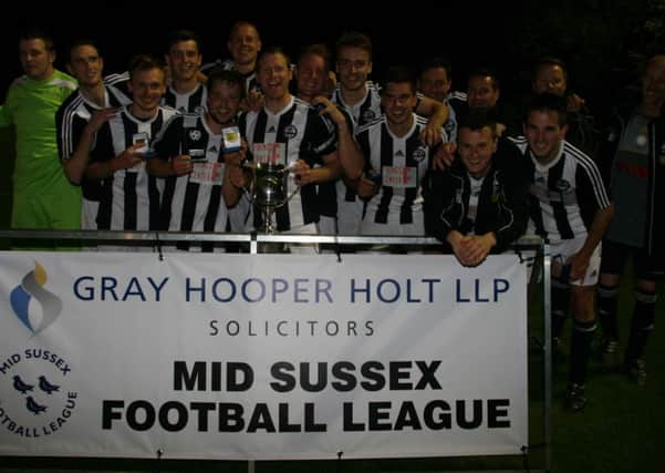 Balcombe players proudly displaying their winners medals and the Mid Sussex Senior Charity Cup.