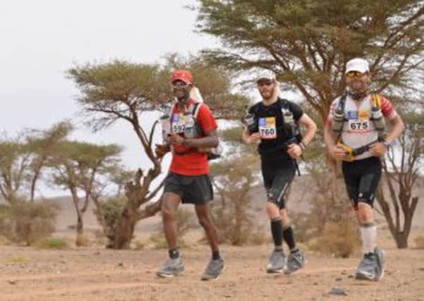 Scott pictured with two other runners tackling some of the tough terrain in Morocco