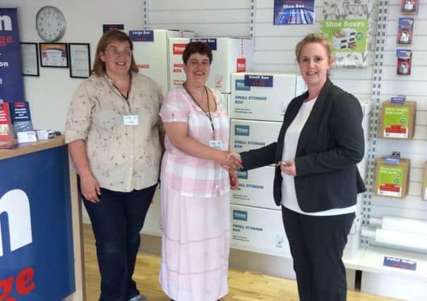 Pictured centre, Hazel Cooper, co-ordinator of Littlehampton's Food Bank picks up the keys to a new storage room donated by Titan Storage