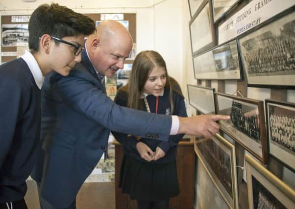 Headteacher Mr Nick Wergan with Steyning students viewing old school photographs SUS-140520-105025001