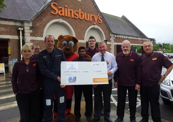 Sainsbury's staff with , store manager Derek Boarer handing the cheque to Air Ambulance pilot Mark Howard-Smith. Dr Dudley the Air Ambulance Mascot is also pictured.