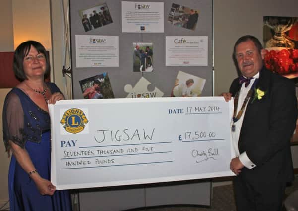 Guildford Lions Club president Trevor Perry hands over a cheque for £17,500 to Jigsaw chiefexecutive Kate Grant - picture submitted
