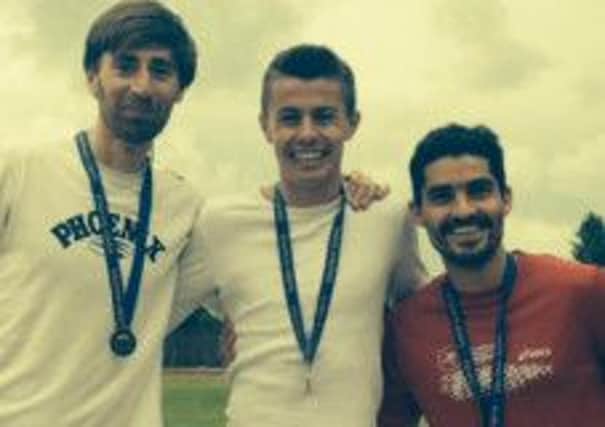 Hastings-based athlete Ross Skelton, centre, with his medal for winning the Sussex senior 1,500m title
