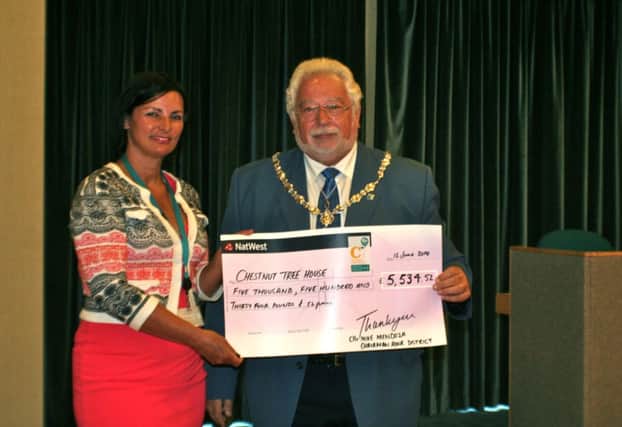 Chestnut Tree House's Caroline Quigley-Jones receives a cheque from Mike Mendoza