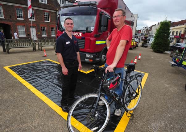 14/6/14- Cycle and road safety event, Battle.  Chris Cook from the 1066 Cycle Club and Eliot Parry from the Fire Brigade discuss lorry blind spots SUS-140614-181009001