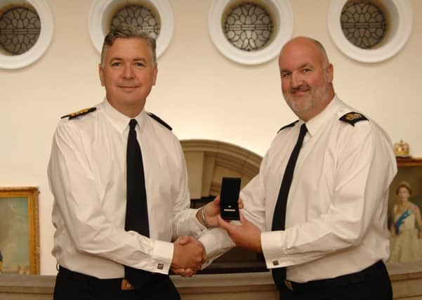 Royal Navy Warrant Officer Tim Bowers (right), who has recently been presented with the clasp to his Long Service and Good Conduct medal by Captain Henry Duffy, the Commanding Officer of Britannia Royal Naval College SUS-140617-123440001