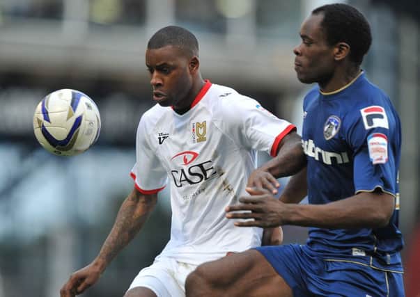 Oldham Athletic's Jean-Yves Mvoto and MK Dons' Izale McLeod battle for the ball during the npower Football League One match at Boundary Park, Oldham. ENGPPP00220130225142220