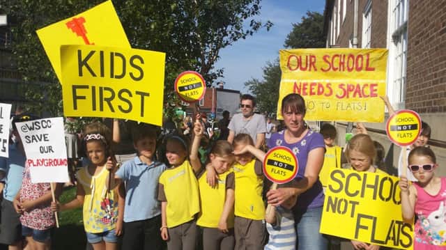 Parents and children protest outside the town hall on Wednesday, June 25