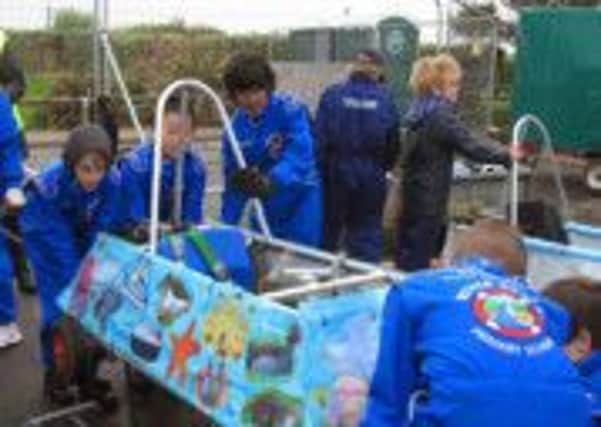 Pupils from the River Beach Primary School, in Littlehampton, getting their electric racer ready SUS-140630-110756001