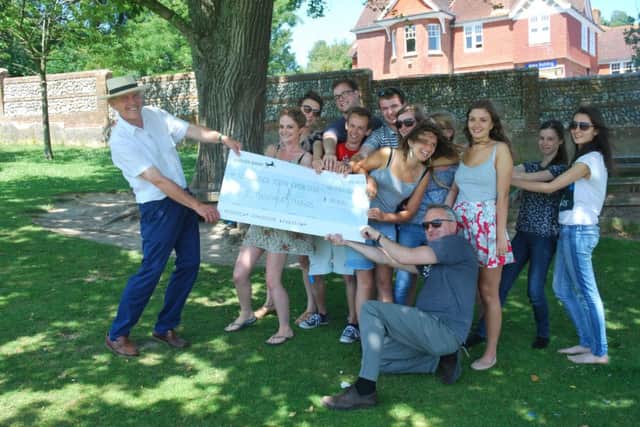 East Sussex Youth Orchestra Members with Nigel Philips (left) chairman of the Friends of the Youth Orchestra, presenting a cheque for 8,000 to Malcolm Warnes (bottom, front), senior manager and co-ordinator for the Youth Orchestra SUS-140722-103550001