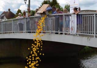 Owen Thomas, 14, tips the rubber ducks into the water from Bramber Bridge