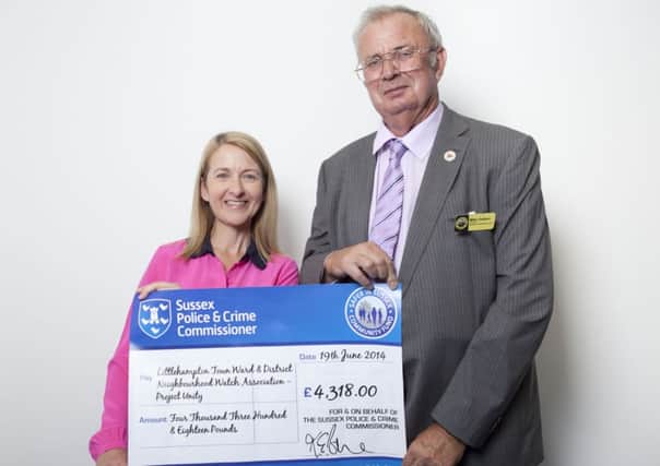 Police and crime commissioner Katy Bourne presents the chairman of the Littlehampton Town and District Neighbourhood Watch Association with a cheque for more than £4,000 SUS-140725-101206001
