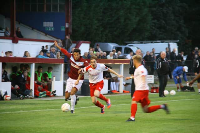 Hastings United winger Taser Hassan (red shirt) tries to take on the Whitstable Town defence at The Pilot Field on Monday night. Picture courtesy Terry S. Blackman