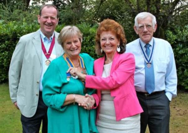 Outgoing President of Storrington Rotary Club Mary Jagger (right) hands over to new President Penny Barnes with Hon. Secretary David Lowe (right) and Hon. Treasurer Alistair Smith looking on. SUS-140818-154049001