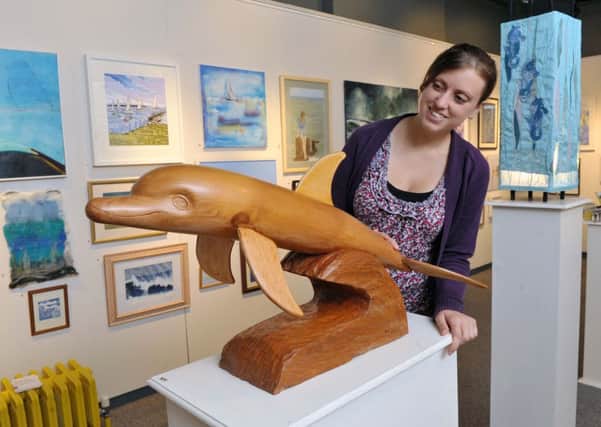 Lucy Ashby with a dolphin crafted by Brian Castle L33922H14