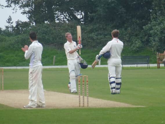 Shawn Johnson (centre) raises his bat to acknowledge his hundred for Bexhill against Hastings Priory. Picture by Simon Newstead (SUS-140709-112013002)