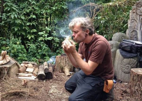 Jonathon Huet starts a fire with flint to cook vitamin-rich berry syrup at WWT Arundel SUS-140929-143920001