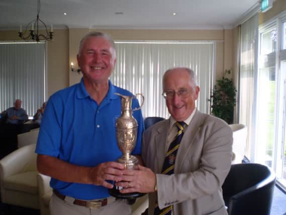 Cooden Beach Golf Club captain Steve Bedwell receives the Bexhill Challenge Cup from Highwoods captain Colin Grant
