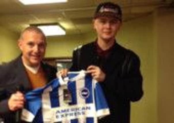 Albion chief executive Paul Barber shows Charlie Hilton the signed shirt for auction