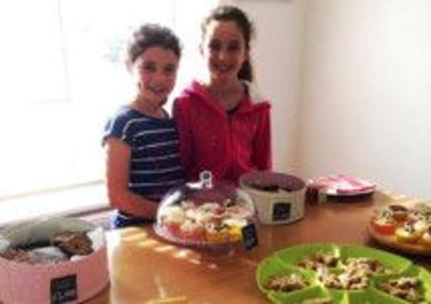 Emmy and Isobella St George with their cakes