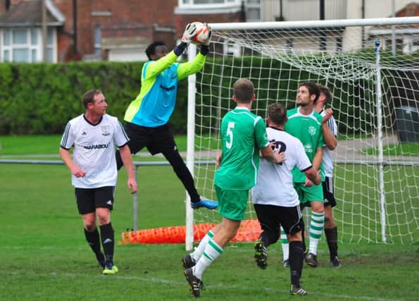 Bexhill United goalkeeper Yankuba Camara claims a cross during the 2-0 win over Rustington. Picture by Steve Hunnisett (SUS-141025-170211002)