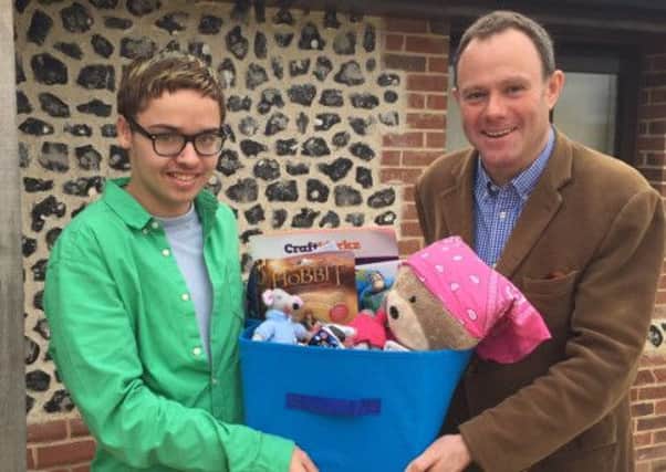 Tyler Murphy, 17, pictured with Arundel and South Downs MP Nick Herbert, right. Tyler has been helping seriously ill children by creating gift boxes to brighten their lives. It comes after he survived a four-year battle against a brain tumour SUS-141028-161325001