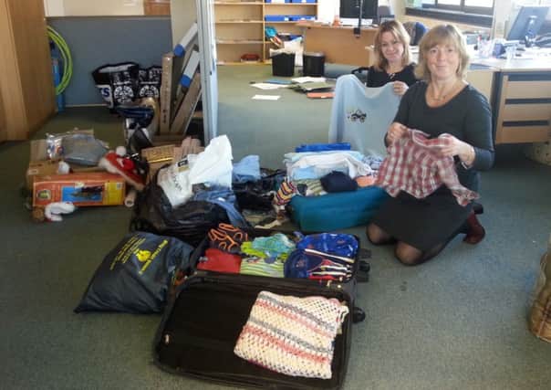 Anya Witos-Richey (left) and Emma Hancox, from the English Language Homestays team, packing up the baby clothes