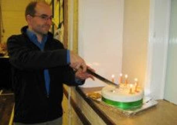 Capel Choral Soceity's conductor, Peter Ford, cutting the choir's anniversary cake SUS-140511-093446001