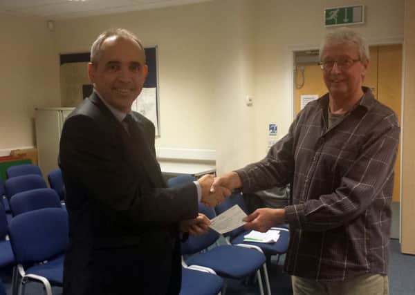 Southwater Parish Council Chairman Mr Peter Buckley presents Mr Andrew Perry of St.Catherines Hospice with a community grant SUS-141211-145307001