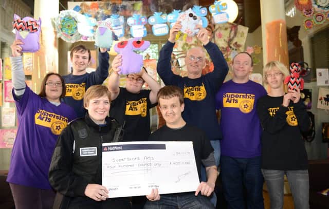 WH 041114  PCSO Helen Green presenting cheque from police to Super Star Arts. Photo by Derek Martin SUS-140411-122003001
