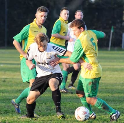 Westfield manager Jethro Warren (right) tangles with Bexhill United striker Jamie Crone. Picture courtesy Jon Smalldon