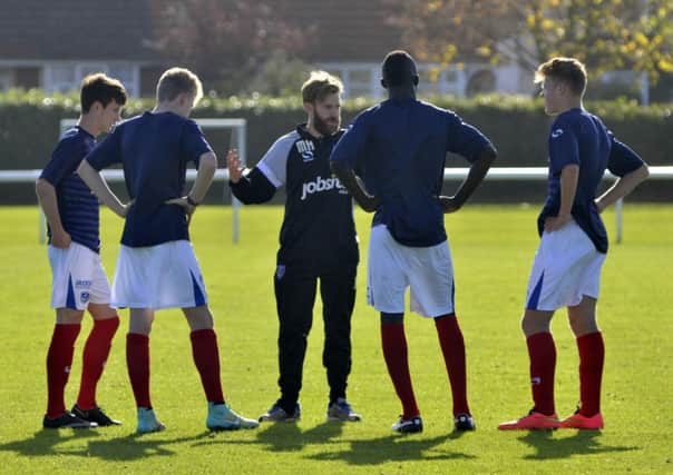 Pompey Academy coach Mikey Harris, centre, briefs his players. Picture: Neil Marshall